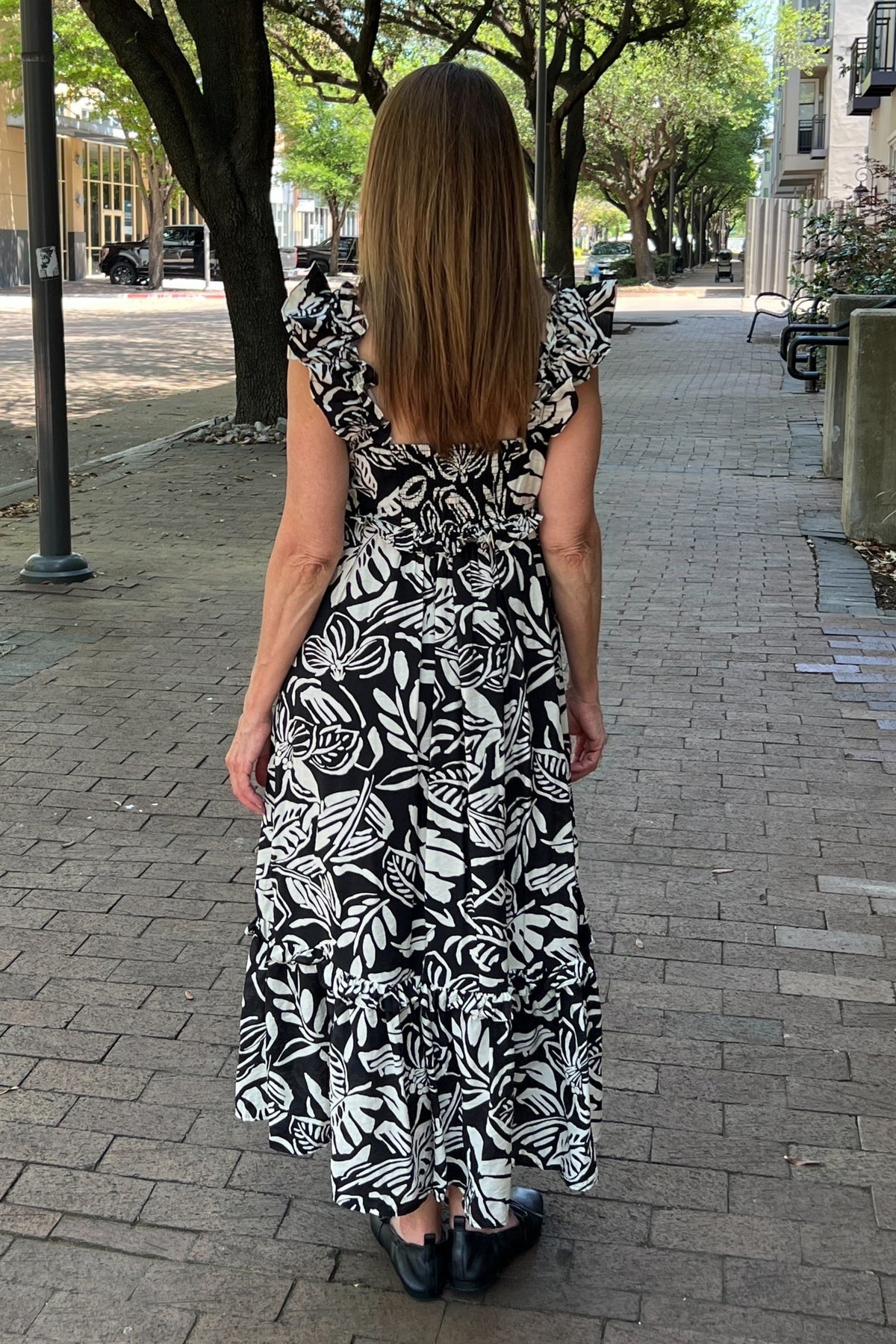 Bold black and white floral dress is lightweight for comfort, and it's lined as well. It has ruffle-style straps. The empire waist has a small ruffle, and the tiered hem has a ruffle as well. Maxi length.