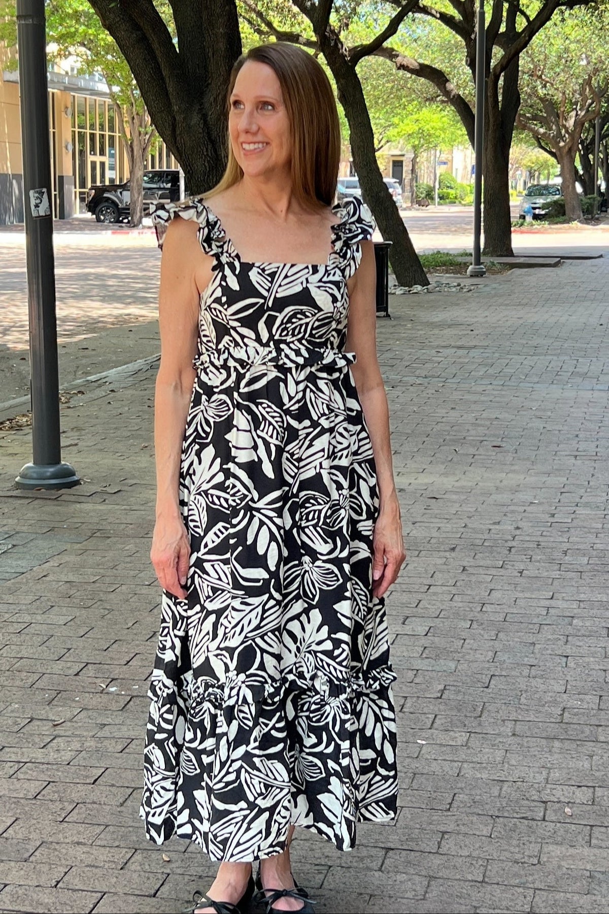 Bold black and white floral dress is lightweight for comfort, and it's lined as well. It has ruffle-style straps. The empire waist has a small ruffle, and the tiered hem has a ruffle as well. Maxi length.