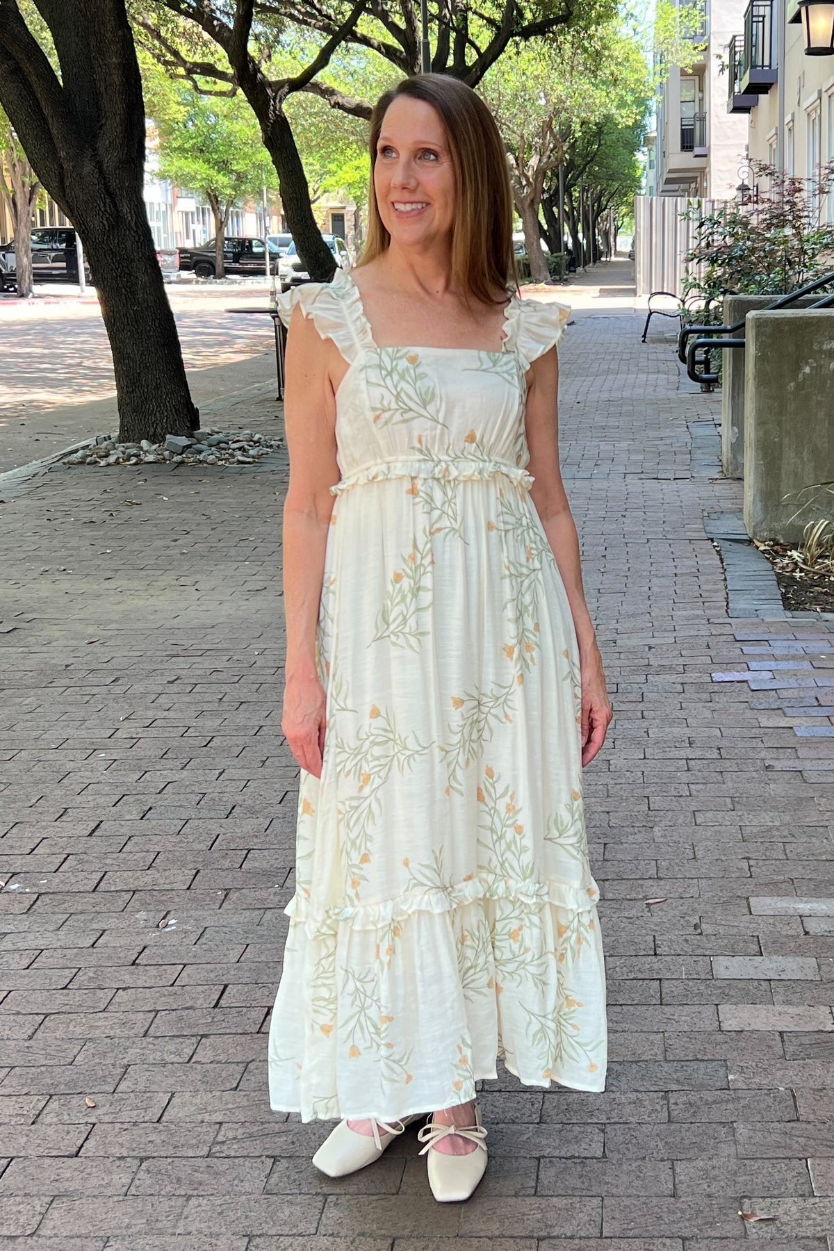 Cream sundress with sage and cinnamon delicate fern pattern. Straps have ruffle embellishment. Length is max with a low-tier hem trimmed with ruffle. Empire waist trimmed with ruffle. Lightweight dress that is fully lined.