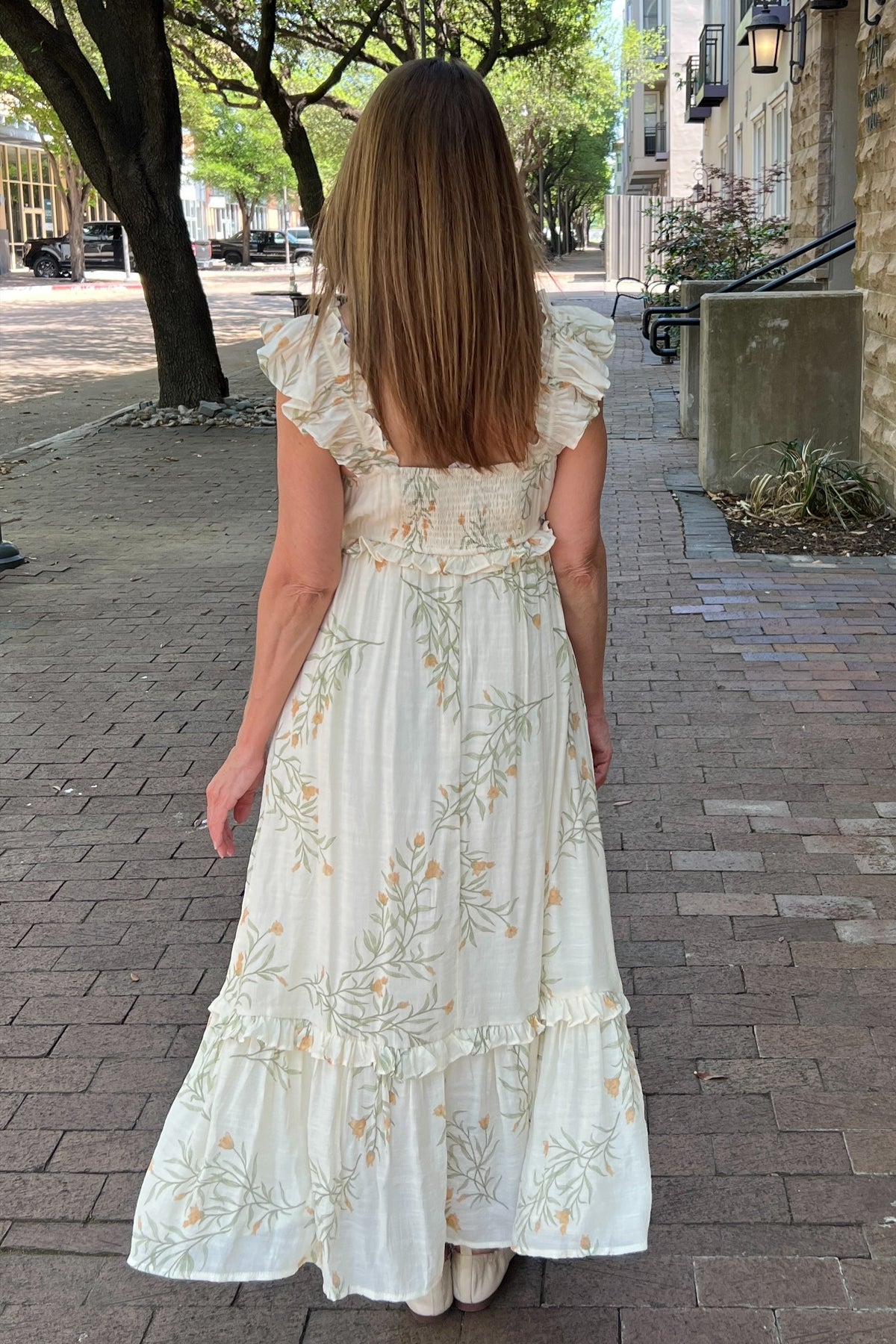 Cream sundress with sage and cinnamon delicate fern pattern. Straps have ruffle embellishment. Length is max with a low-tier hem trimmed with ruffle. Empire waist trimmed with ruffle. Lightweight dress that is fully lined.