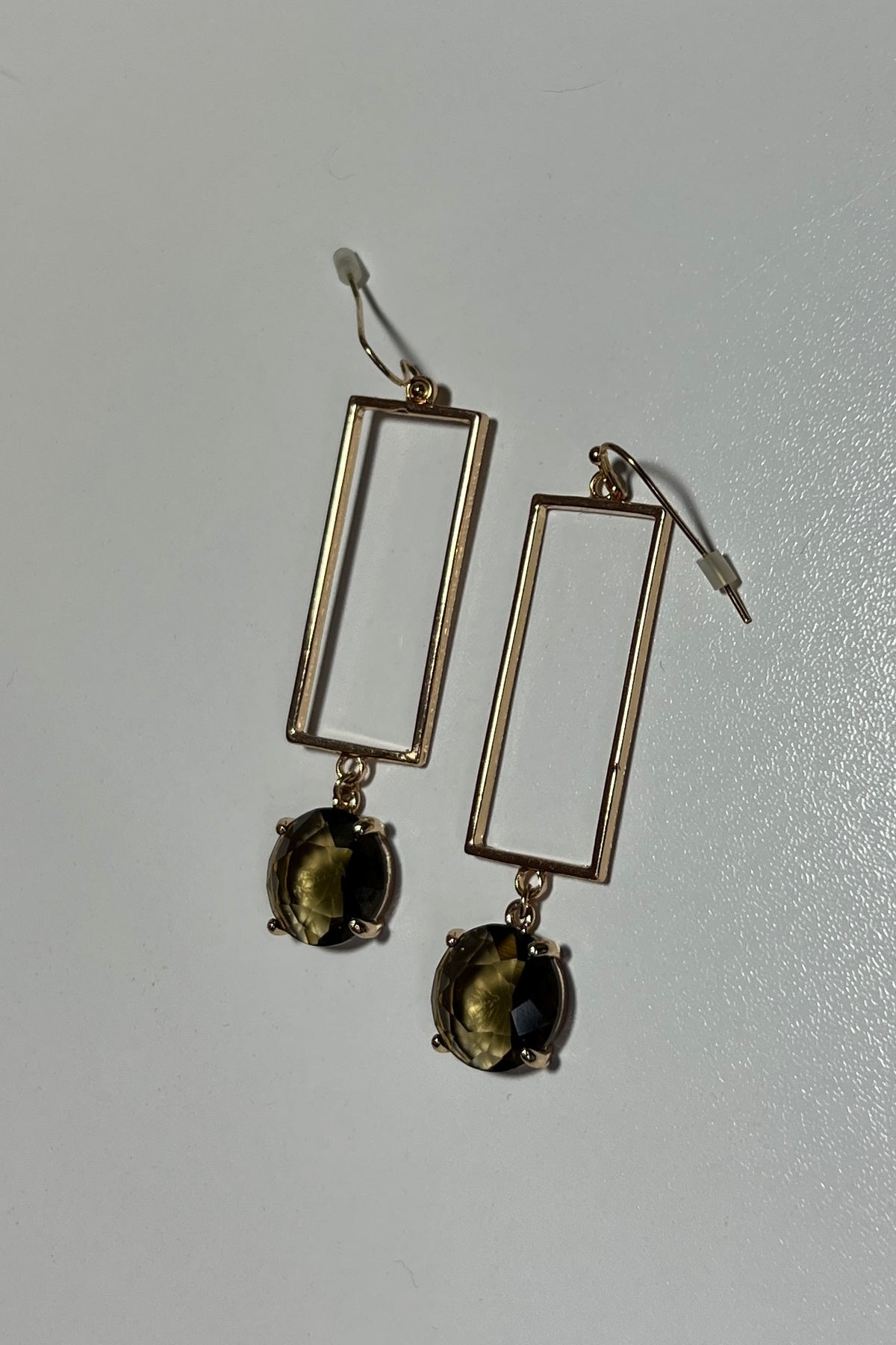 Earrings with a rectangular gold shape with synthetic andalusite stone. Hook earring back. Shown on a white background.