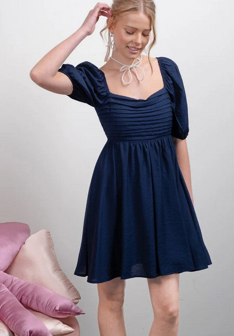 This navy dress will be a staple for your closet. It's fully lined. The softly puffed sleeves are not overpowering, and the pleated bodice adds texture to the look. 