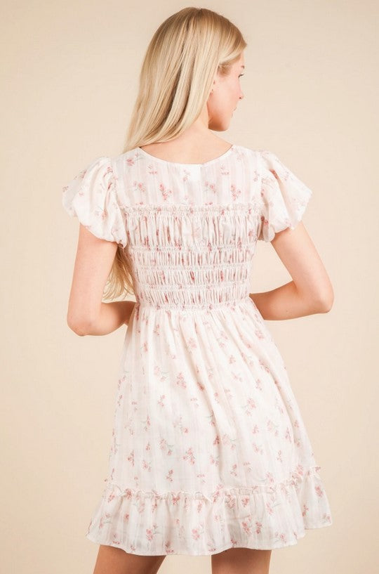Sweet pink ditsy floral dress is darling for upcoming end-of-year parties and showers. Sleeves are slightly puffed, and the crew-neck collar has a bow detail. The bodice is smocked, and the dress is fully lined. 