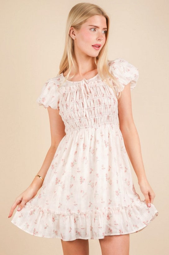 Sweet pink ditsy floral dress is darling for upcoming end-of-year parties and showers. Sleeves are slightly puffed, and the crew-neck collar has a bow detail. The bodice is smocked, and the dress is fully lined. 