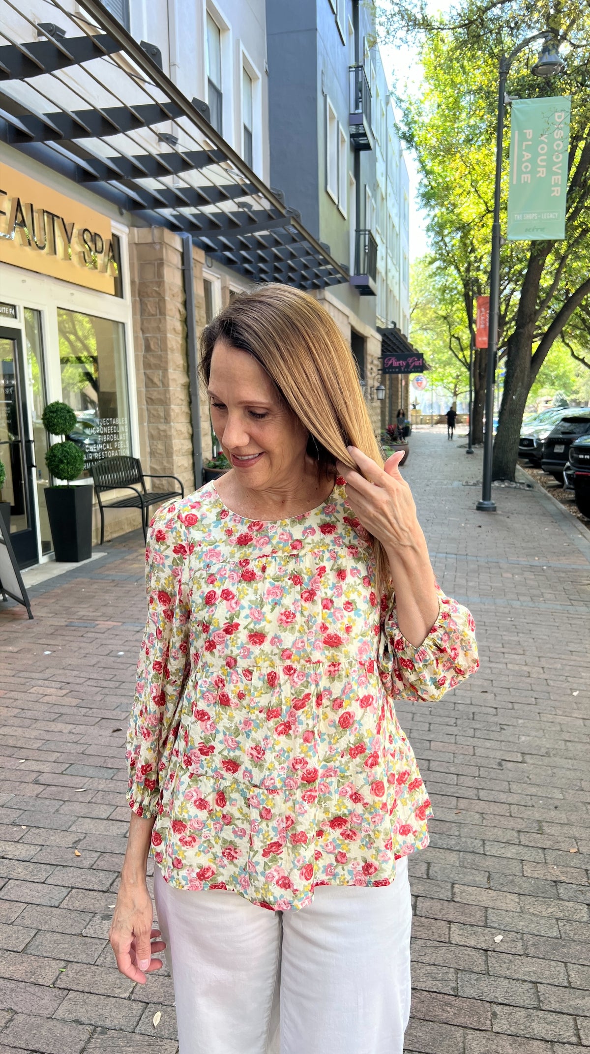 Buttery cream tiered blouse with rose, red and green spring floral pattern. Scoop neck line. Three-quarter length sleeves with elastic cuff. Top is fully lined.