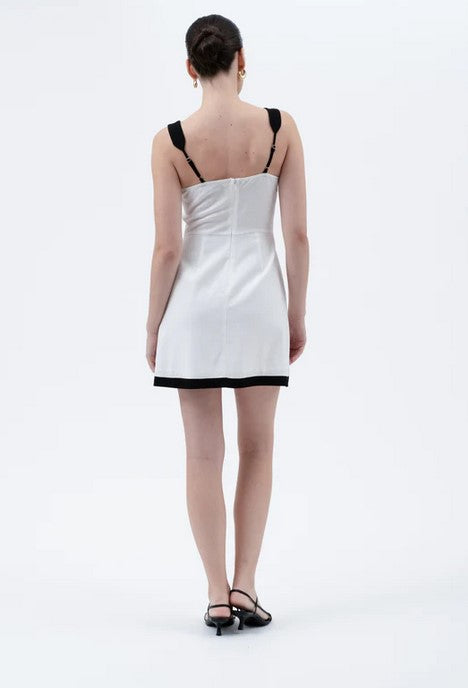 Sexy summer dress has a dramatic contract collar and hem. Dress is lined across the breast,  and the skirt is fully lined as well. Zip up back with adjustable straps.