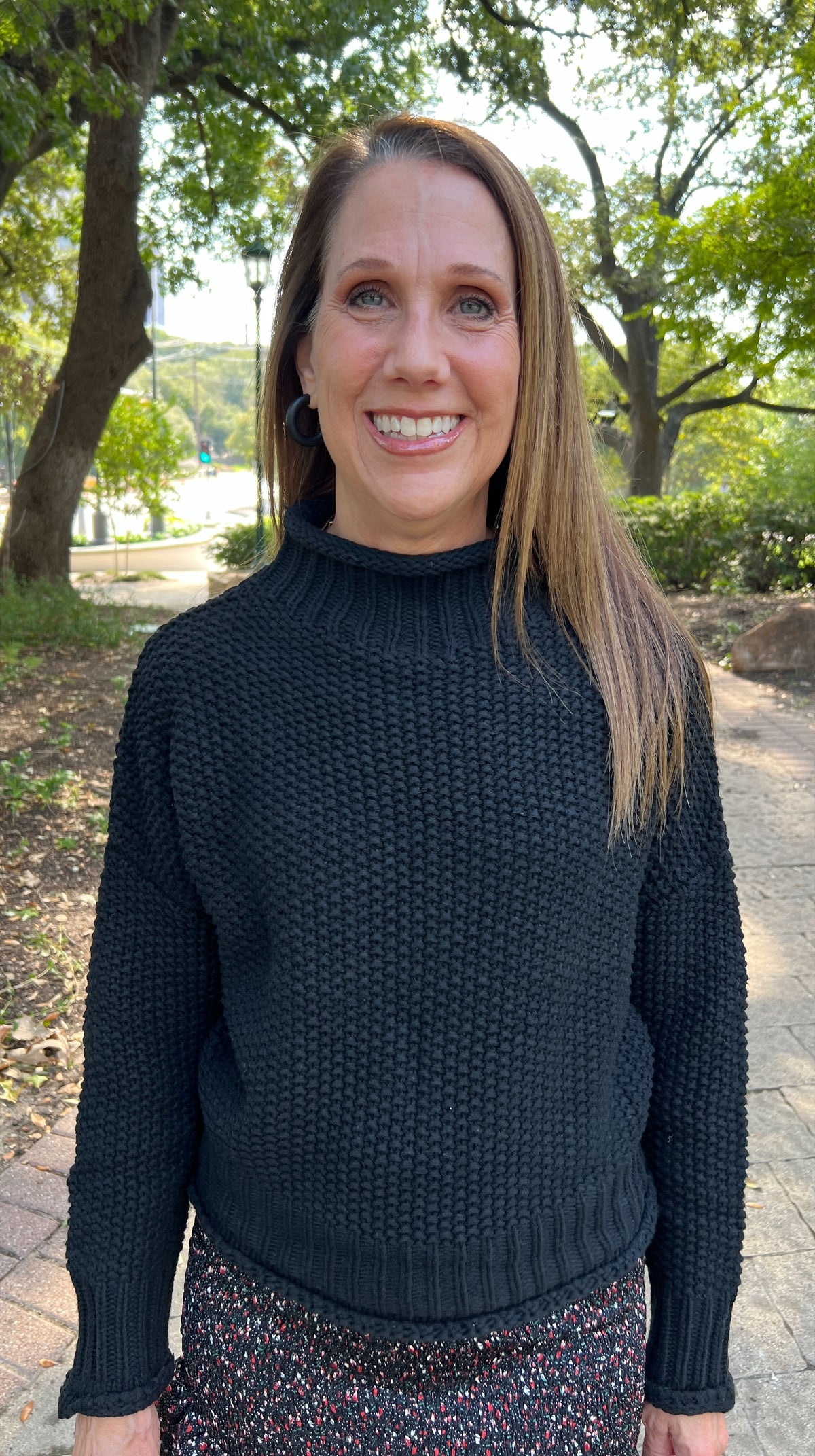 This basic black mock turtleneck sweater has a bubble-like texture to add visual interest, and the length hits just at the waist, making it perfect to wear with jeans or skirts. 100% cotton.