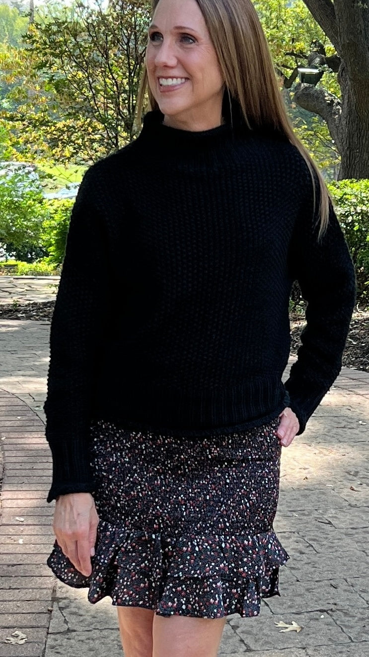 This basic black mock turtleneck sweater has a bubble-like texture to add visual interest, and the length hits just at the waist, making it perfect to wear with jeans or skirts. 100% cotton.