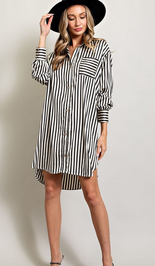 Black and white striped shirt dress made of satin material. Dress has a breast pocket and shirt cuffs. 