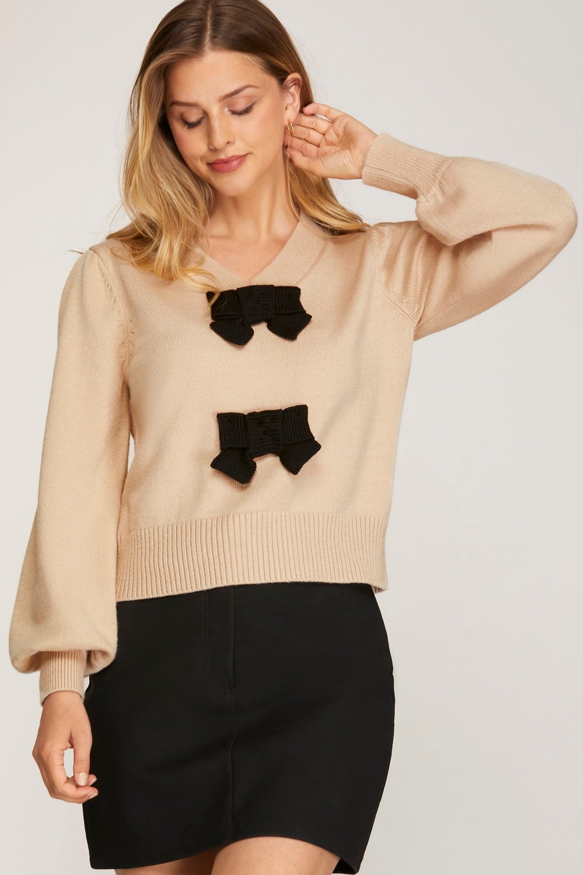 Bring on the bow season! This sweater is so cute on, and it is so soft! The taupe base color is trending, and the black bow details add elegance. The v neck is not too deep, and the cuffed sleeves fit right at the wrist. 